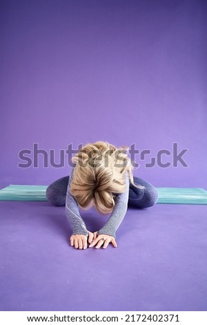 A woman performing the pose of a child in yoga classes in the studio on a rug. sports, yoga, stretching