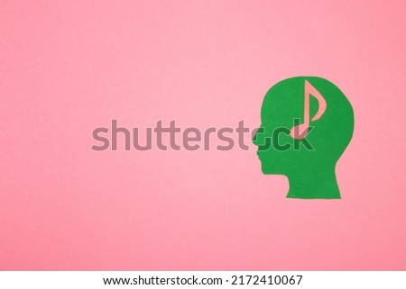 green paper head with brain musical note on pink background with copy space, creative modern design