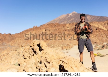 Young man taking pictures on a road trip. Man making memories on the mountain