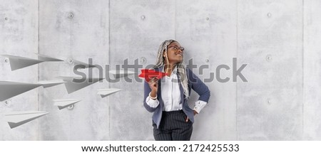 Young beautiful african woman holding hand model paper air plane. Design of travel concept with air plane on empty gray color background Royalty-Free Stock Photo #2172425533