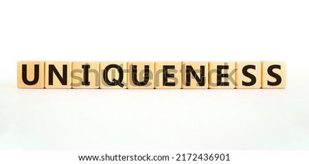 Inclusiveness and uniqueness symbol. Wooden cubes with the word 'uniqueness'. Beautiful white background. Business, inclusiveness and uniqueness concept. Copy space.