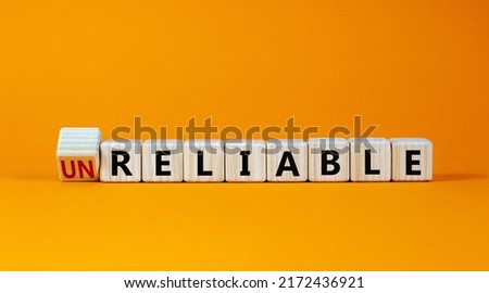 Unreliable or reliable symbol. Turned wooden cubes and changed the word unreliable to reliable. Beautiful orange background, copy space. Business and unreliable or reliable concept. Royalty-Free Stock Photo #2172436921