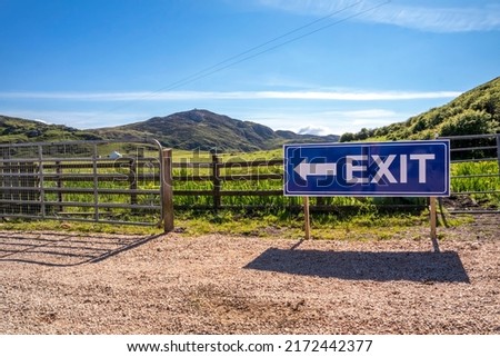 Exit sign on wooden fence of a farm and camping site