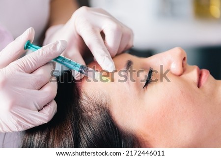 Injectable tissue stimulator on woman face in beauty salon. Aesthetic medicine Royalty-Free Stock Photo #2172446011