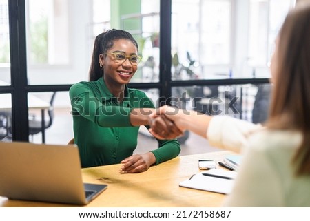 Business women shaking hands in the office during business meeting. Two diverse female entrepreneurs on meeting in boardroom. Female recruiter and employee confirm hiring Royalty-Free Stock Photo #2172458687