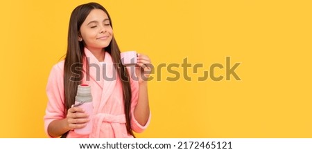 dreamy teen girl in home terry bathrobe with thermos bottle, thirsty. Horizontal poster of isolated child face, banner header, copy space. Royalty-Free Stock Photo #2172465121