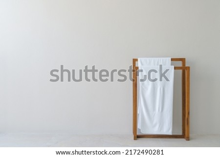 White towels on wooden towel hangers against a beige wall Royalty-Free Stock Photo #2172490281