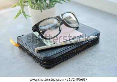 A picture of glasses perched on a Bible.