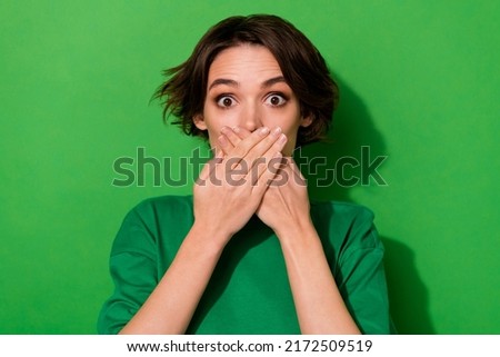 Photo of impressed worried girl arms palms cover face mouth look camera isolated on green color background Royalty-Free Stock Photo #2172509519