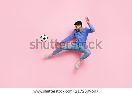 Full length photo of pretty funky man wear long sleeve shirt jumping high playing football isolated pink color background