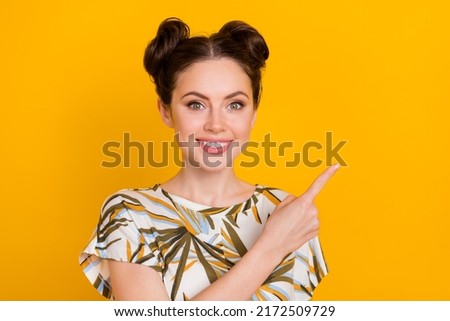 Photo of cute adorable woman wear print t-shirt pointing finger empty space isolated yellow color background