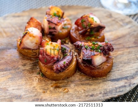 Spanish starter dish in fish restaurant in Getaria, grilled octopus with roasted potatoes and paprika, Basque Country, Spain Royalty-Free Stock Photo #2172511313