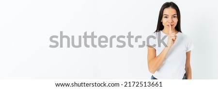 Young woman showing shh keep the secret sign with finger to lips standing on white background, wide banner with copy space
