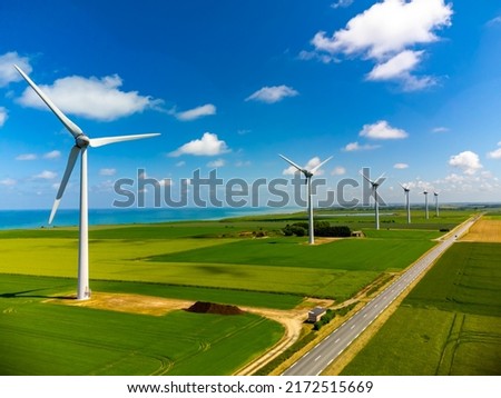 Aerial view on modern wind mills, green grain fields and blue Atlantic ocean in agricultural region Pays de Caux in Normandy, France in summer Royalty-Free Stock Photo #2172515669
