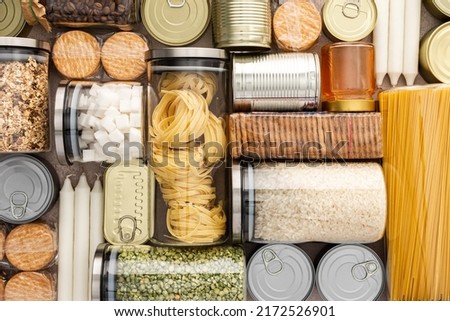 Top view of the background of the necessary products for the period of the pandemic or famine or quarantine and isolation, food stock, the concept of stay at home, donated products, grocery delivery Royalty-Free Stock Photo #2172526901