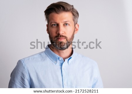 Portrait of middle aged man wearing shirt and looking at camera while standing at isolated background. Copy space.