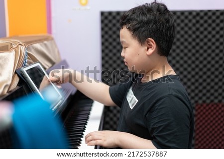 boy point to tablet for playing piano