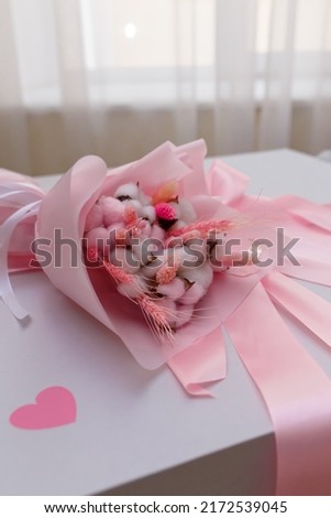 Flowers bouquet on white present box with pink ribbon and bow. Mothers, Valentines, women day, wedding, birthday