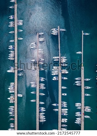 High aerial view of a marina with moored sailboats and yachts over turquoise sea Royalty-Free Stock Photo #2172545777