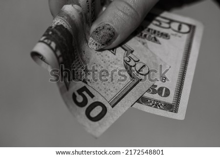 Hands giving money like a bribe or tips. Holding US dollars banknotes on a blurred background, US currency