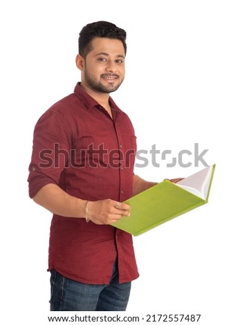 Young happy man holding and posing with the book on white  background.
