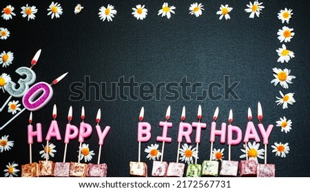 Happy birthday background with number 30. Copy space. Pink happy birthday candles on a black background. Happy birthday flower frame.
