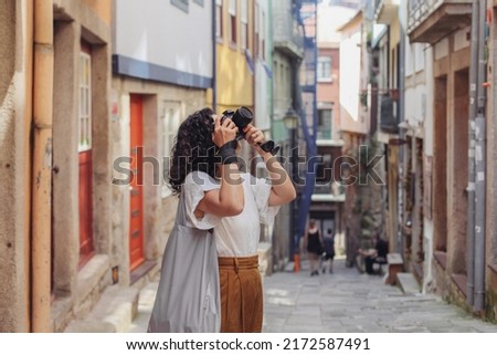 Woman with a professional camera walking on a European street, taking pictures of streets 