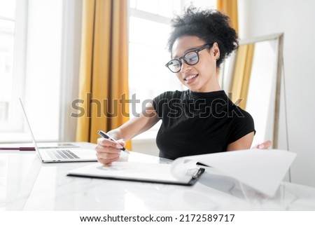 A woman with glasses, a manager works in an office, uses a laptop, makes a report to a finance company, coworking space