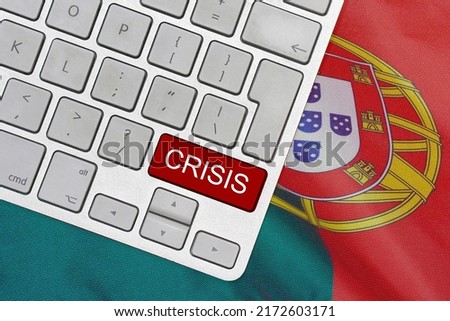 White computer keyboard with red button with word of crisis on Portugal flag background. Global economic, political and financial crisis. Economic crisis and economic recession in Portugal