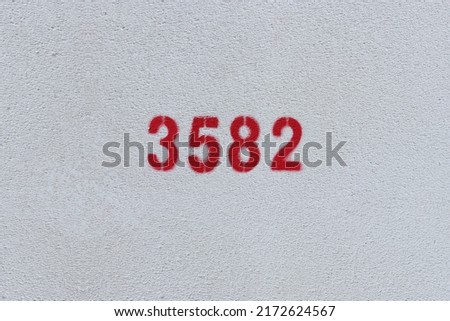 Red Number 3582 on the white wall. Spray paint.
