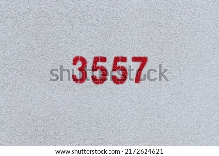 Red Number 3557 on the white wall. Spray paint.
