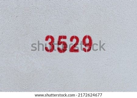 Red Number 3529 on the white wall. Spray paint.
