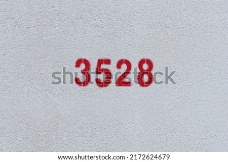 Red Number 3528 on the white wall. Spray paint.
