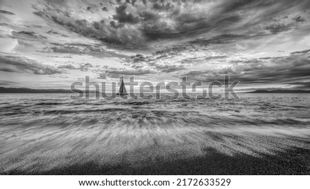 Detailed Clouds Are Overhead As A Small Boat Moves Toward The Shining Light Black And White 16.9 Royalty-Free Stock Photo #2172633529
