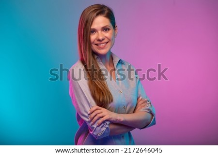 Happy business woman with arms crossed portrait in neon lights. Businesswoman isolated on neon multicolored background.