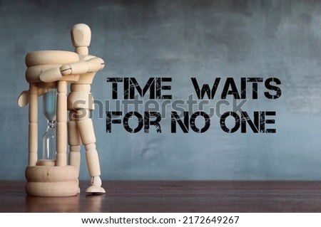 Wooden doll hug sandglass with quotes "Time waits for no one". Time management concept.