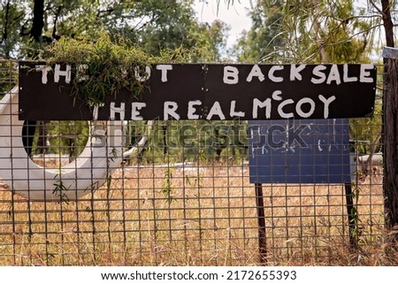 Sign for "The Out Back Sale The Real McCoy" on a fence at the Rubyvale gemfields Australia