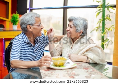 Happy old indian  couple enjoying meal together at home, asian Retired elderly husband and wife eating noodles, spend time. retirement life. love and care. Royalty-Free Stock Photo #2172665823