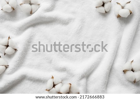 Cotton flowers on a white terry towel with copy space. Royalty-Free Stock Photo #2172666883