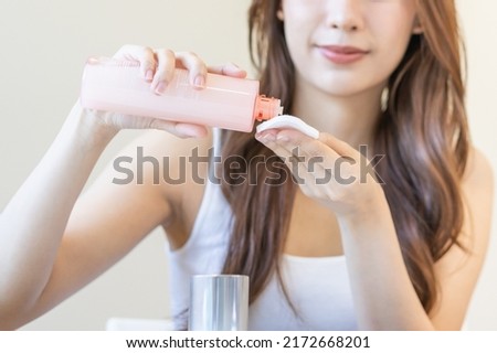 Happy beauty, attractive asian young woman hand in holding cotton pad, applying cleansing, lotion facial wipe on her face, removing makeup before shower in bathroom, skin care on white background. Royalty-Free Stock Photo #2172668201
