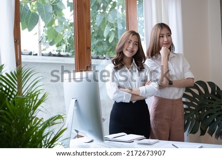 Two young businesswoman discussing business strategy using digital tablet