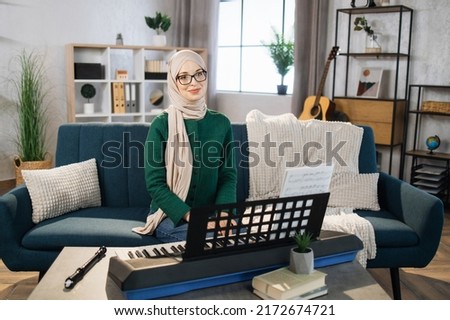 Muslim music teacher conducts a lesson on playing a musical instrument over the Internet. Piano lessons online and online music training during quarantine for the coronavirus pandemic.
