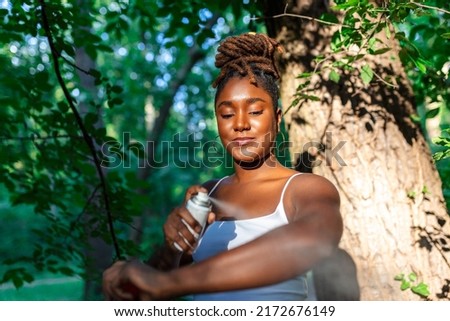 Woman applying insect repellent against mosquito and tick on her arms during hike in nature. Skin protection against insect bite Royalty-Free Stock Photo #2172676149