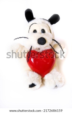 Funny cute dog  toy  with a heart.  Preparation for a romantic holiday. Valentines Day, Birthday  and love Concept. White background