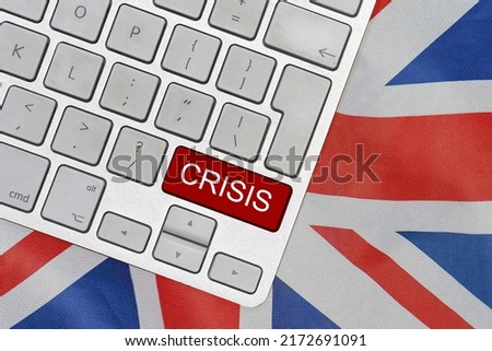 White computer keyboard with red button with word of crisis on UK flag background. Global economic, political and financial crisis. Economic crisis and economic recession in Britannia