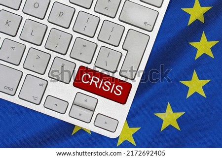 White computer keyboard with red button with word of crisis on EU flag background. Global economic, political and financial crisis. Economic crisis and economic recession in Europa Royalty-Free Stock Photo #2172692405
