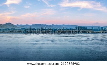 Empty asphalt road and modern city skyline with mountain scenery at sunset. high angle view.