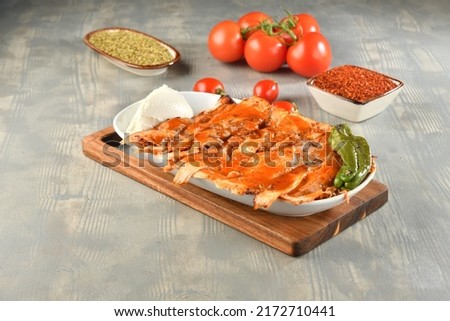 Portion of chicken rotates on the plate served with tomatoes, peppers and yoghurt on wooden table