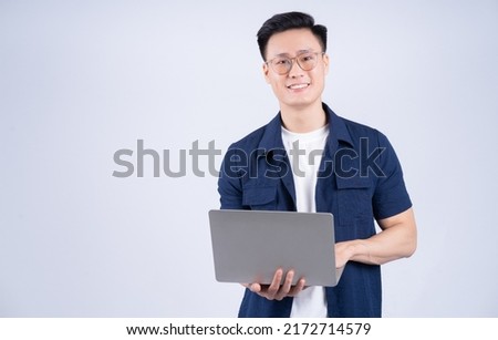 Young Asian man using laptop on white background