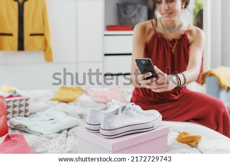 Fashionable woman decluttering her wardrobe, she is selling her used clothes and accessories online Royalty-Free Stock Photo #2172729743